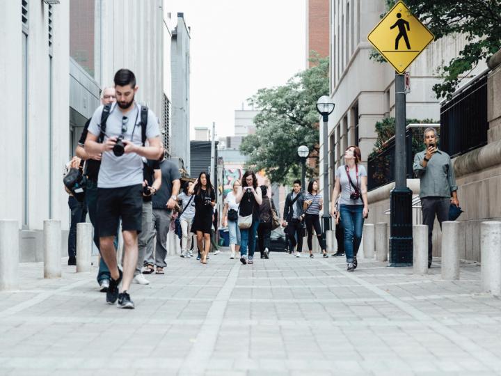 People walk along a busy sidewalk.